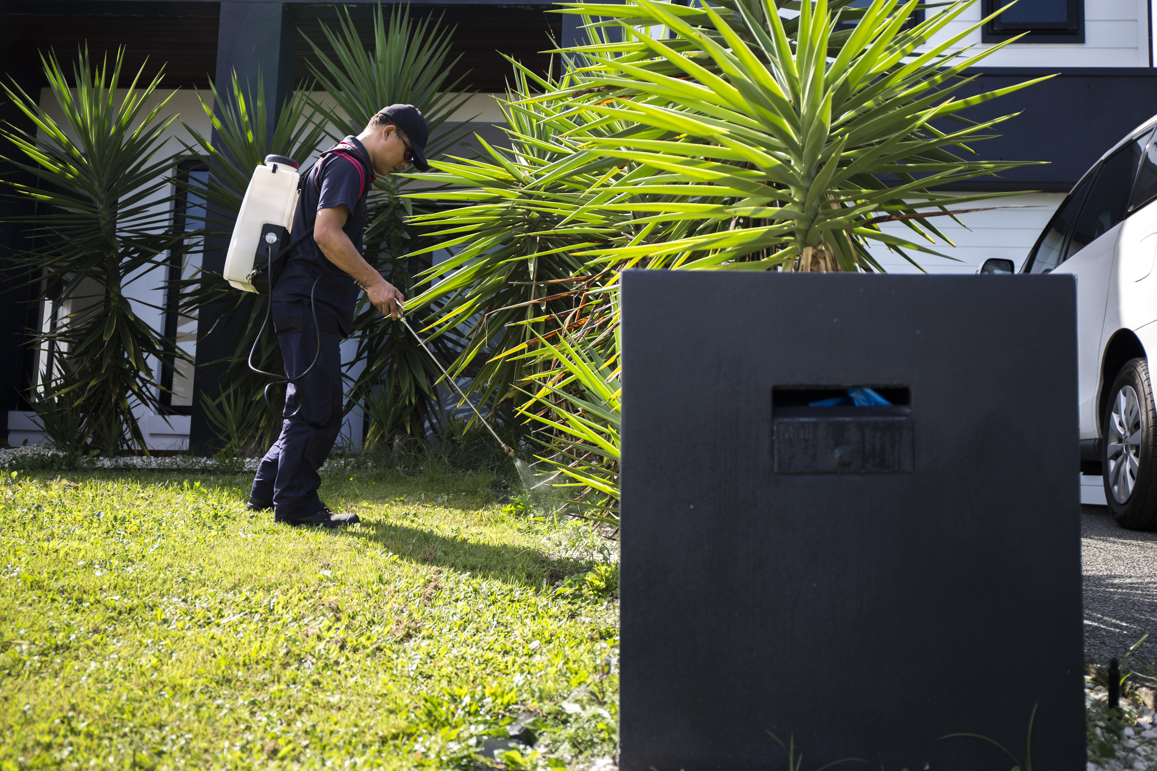 A technician spraying the perimeter of the property with an eco friendly product.