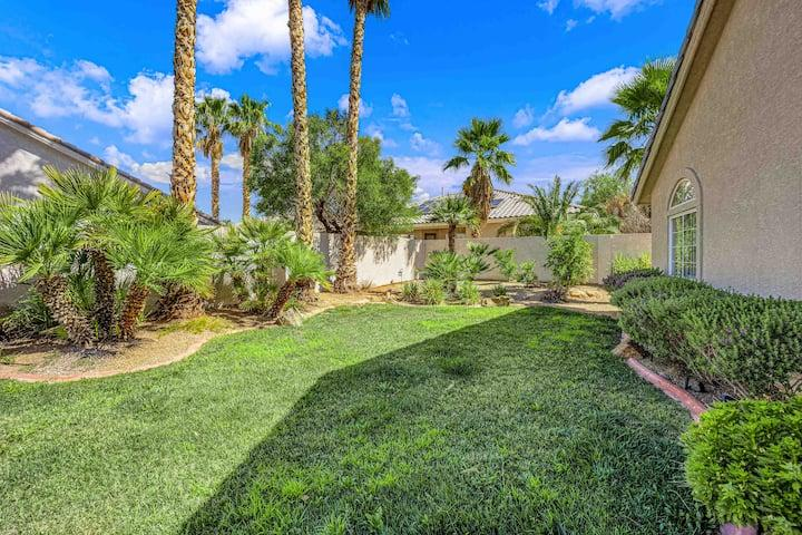 A hot Las Vegas yard with a brick wall and palm trees.